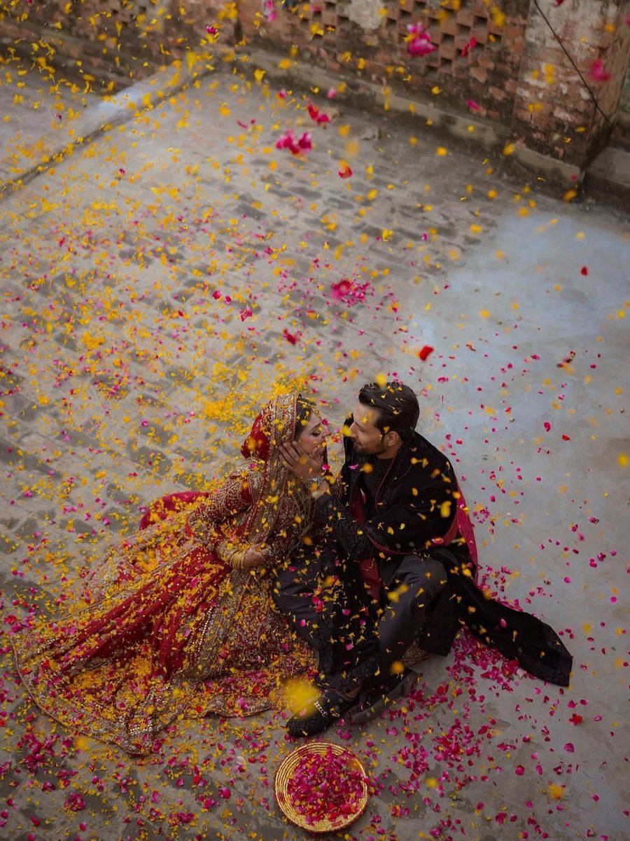 Bride and groom under falling rose petals at a Wedding Alley event